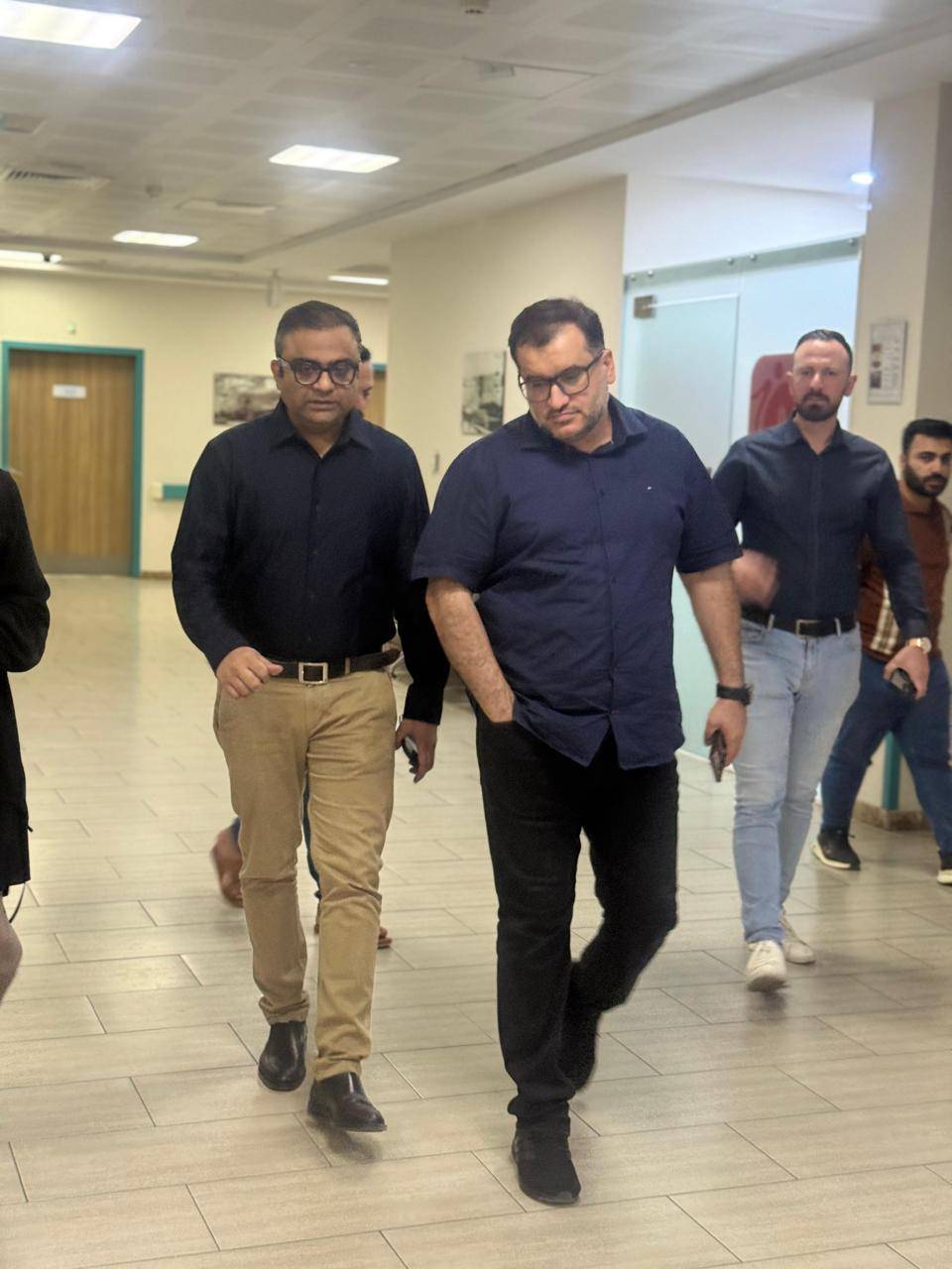 Dr. Ankur Singh walking with international colleagues and delegates in hospital